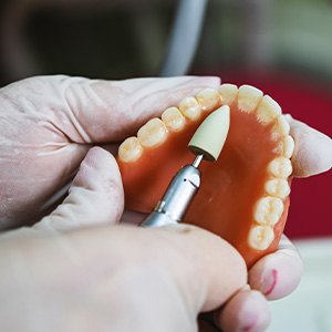 Lab tech filing dentures