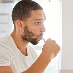 Man brushing his teeth at home