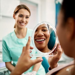 Patient smiling at reflection in treatment chair