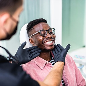 Dentist looking at smiling patient's teeth