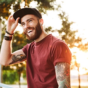 Young man in a red shirt smiling outside