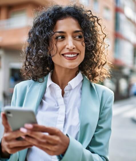 Woman in a business suit smiling with dental implants in Medford