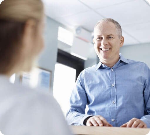 Man smiling at a dental office receptionist
