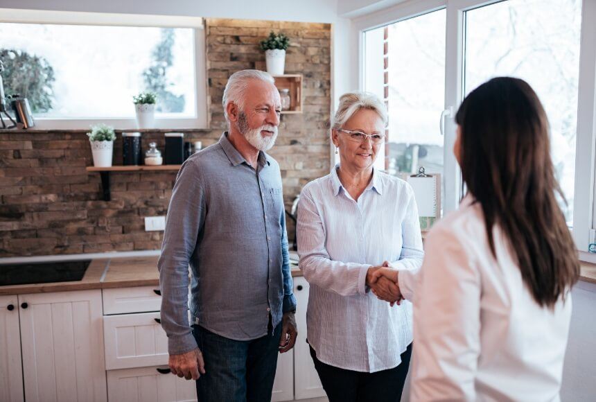 Older couple shaking hands with a dental team member