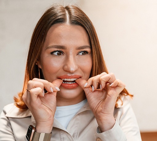 Patient putting on clear aligner in treatment room