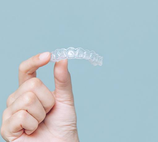 Closeup of patient holding clear aligner