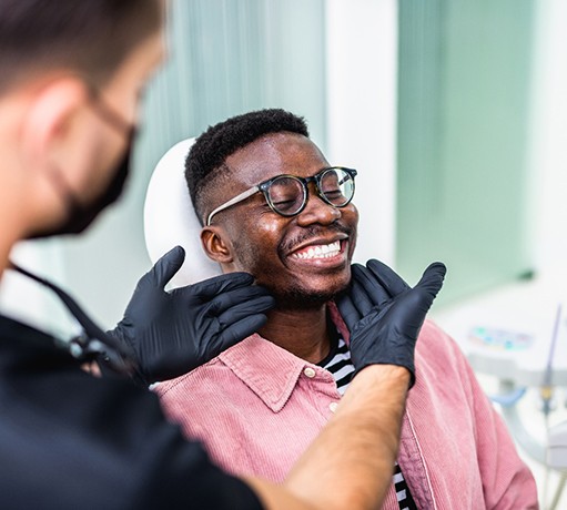 Dentist looking at smiling patient's teeth
