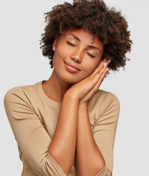 Woman making a pillow shape with her hands and pretending to sleep