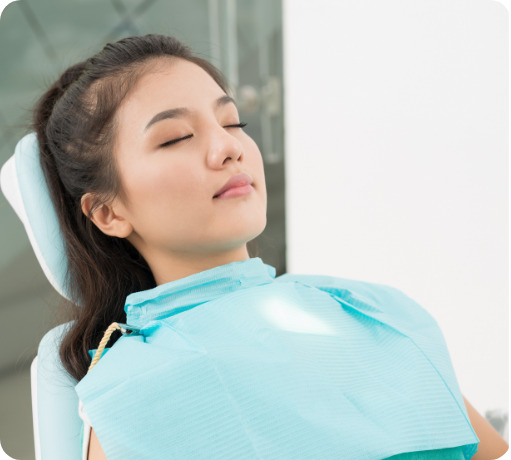 Woman leaning back in the dental chair with her eyes closed