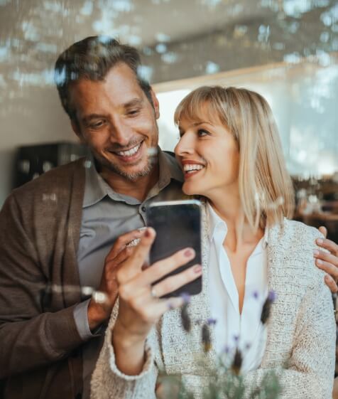 Man and woman smiling at home after receiving dental services in Medford