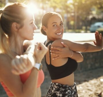 Two women stretching in exercise clothes