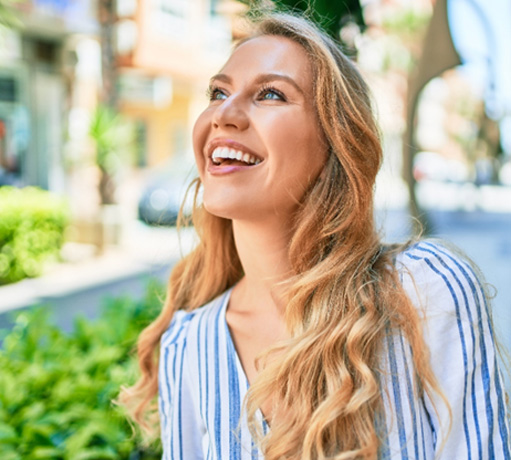 Woman with white teeth smiling outside