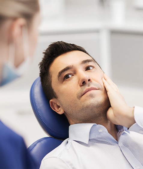 Man talking to his dentist before wisdom teeth extraction in Medford