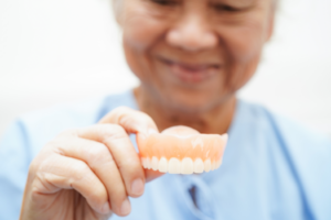 a patient holding and examining their dentures